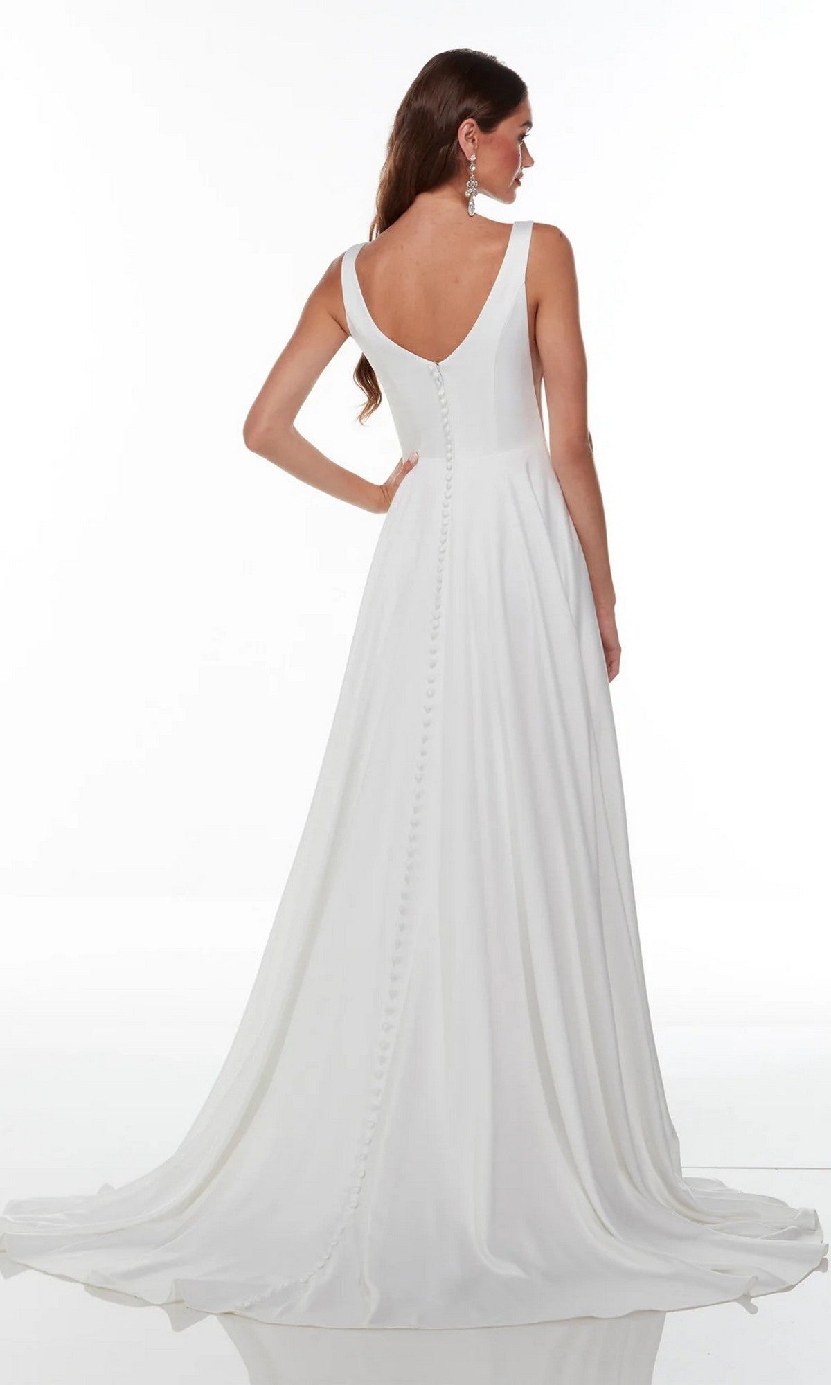 A woman wearing the Alyce 7053 Long White Dress, featuring a sleeveless satin bodice with a V-back and button detailing, stands against a plain white background.